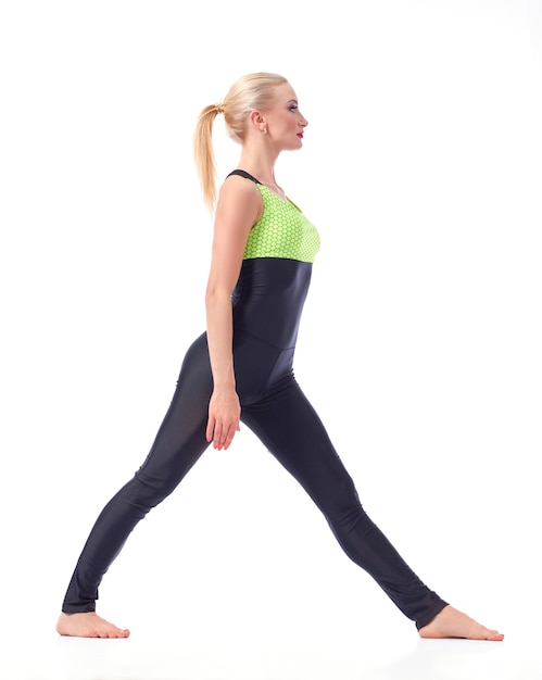 Free photo focused on fitness. full length studio shot of a female gymnast preparing to do splits posing isolated on white sports gymnastics fitness concept