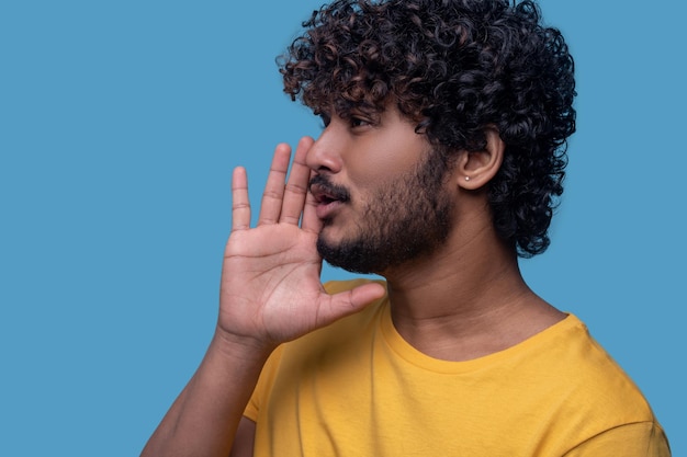 Free photo focused good-looking young indian man calling someone