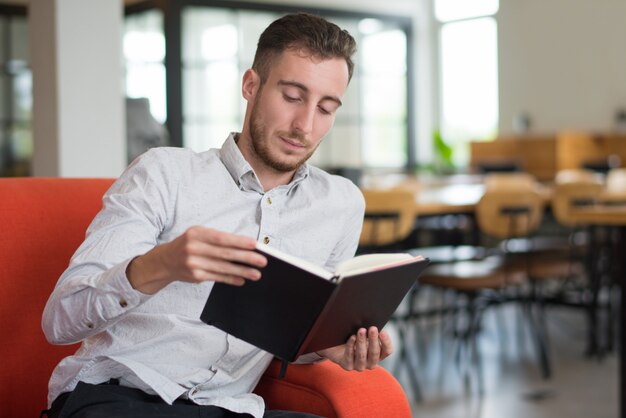 ロビーのソファーで読書を集中させた男