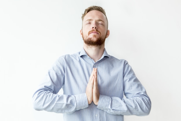 Бесплатное фото Сосредоточенный человек, держащий руки вместе и молясь