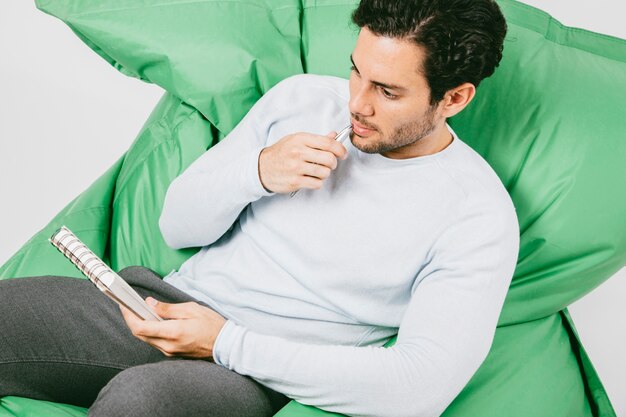 Focused man on the sofa with notebook and pen