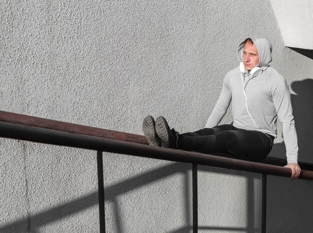 Focused man warming up on railing