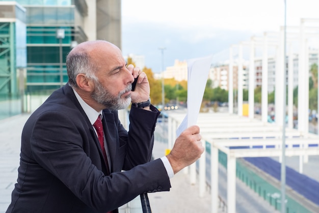 Free photo focused mature businessman reading document