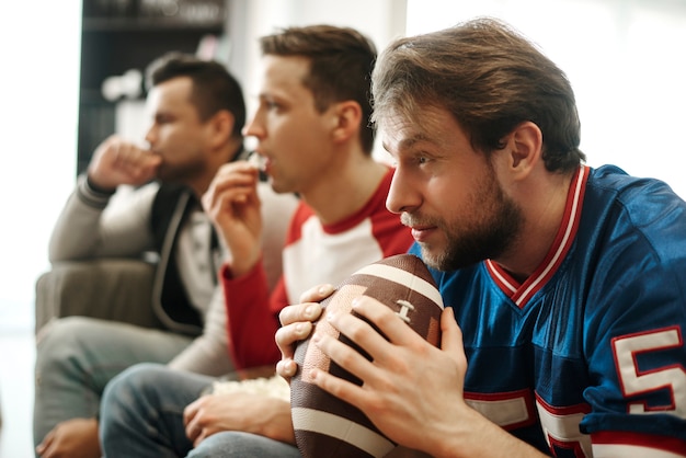 Focused  men watching football game at home