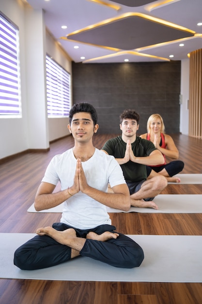 Focused people meditating at yoga class