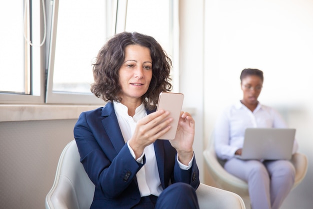 Free photo focused serious businesswoman reading content