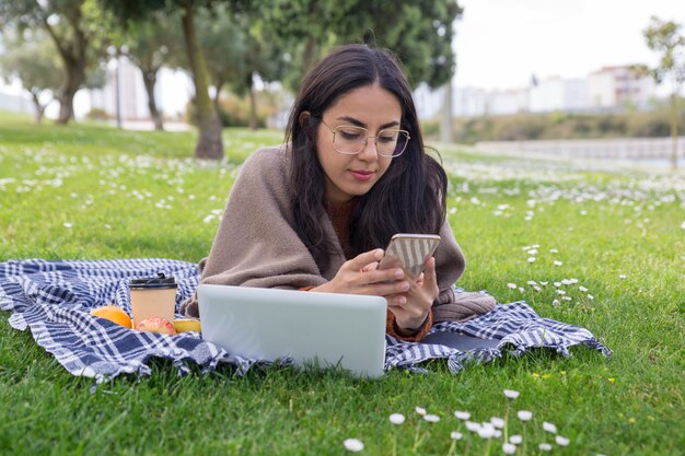 Focused serious girl using gadgets in park