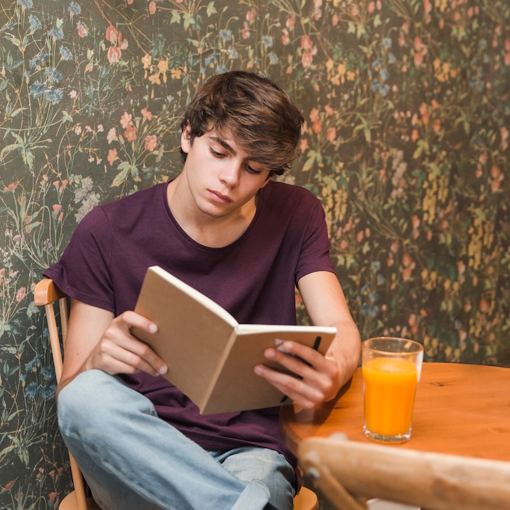 मुफ़्त फोटो focused teenager reading in cafe