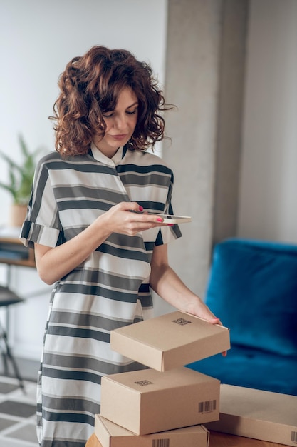 Focused woman scanning the QR code on the package