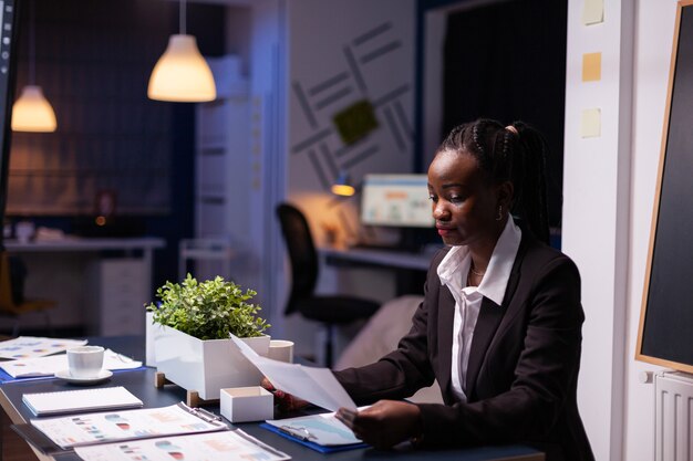 Focused workaholic Young businesswoman working at company financial charts presentation late at night in meeting office room