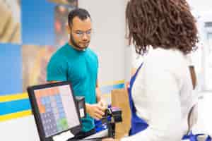 Free photo focused young man paying bill in store