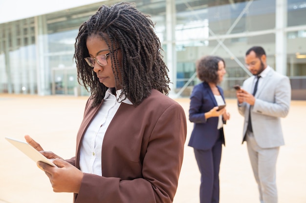 Focused young professional with tablet working on project