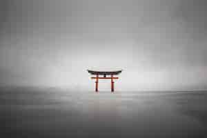 Free photo foggy shot of the floating torii of miyajima, japan during rain