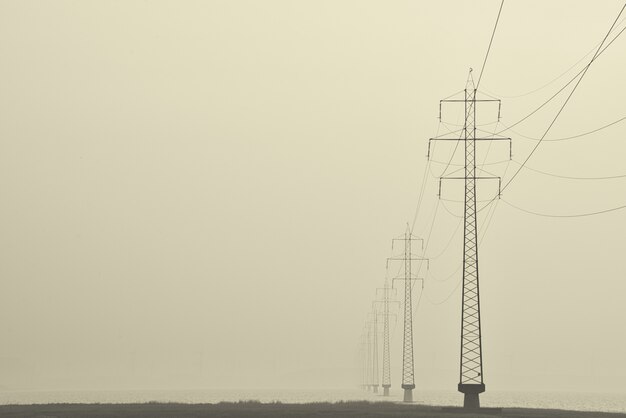 通りの真ん中にある送電鉄塔の霧のショット