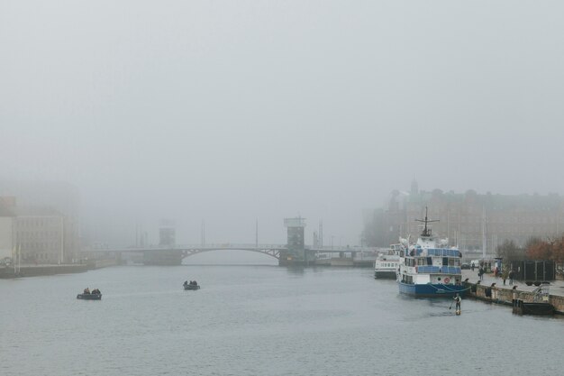 Foggy weather in city with channel