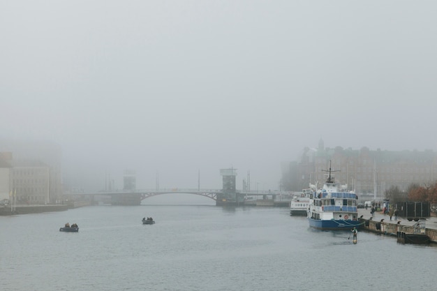 Foggy weather in city with channel