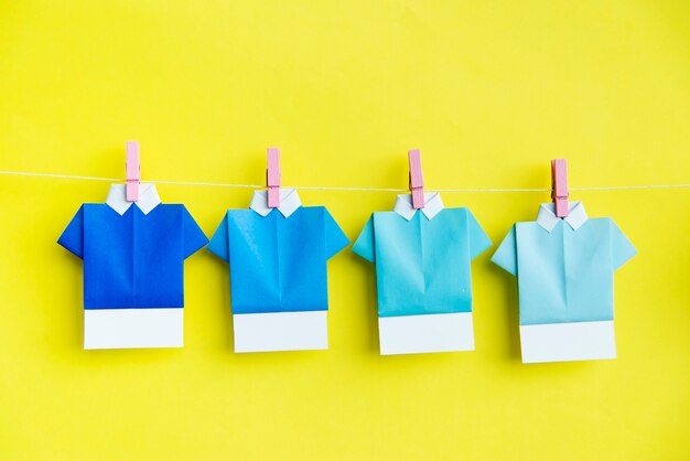 Folded paper shirts hanging on clothes line