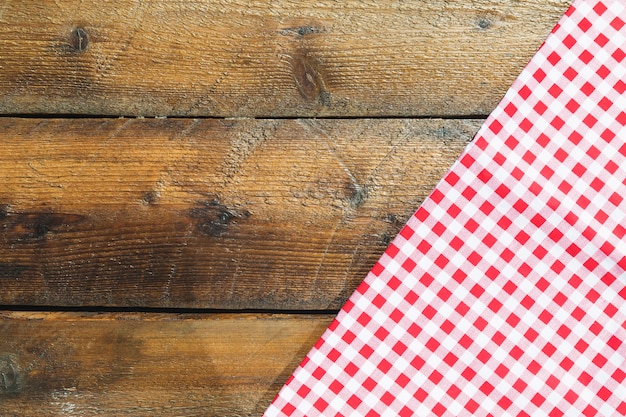 Folded red checkered napkin on wooden table