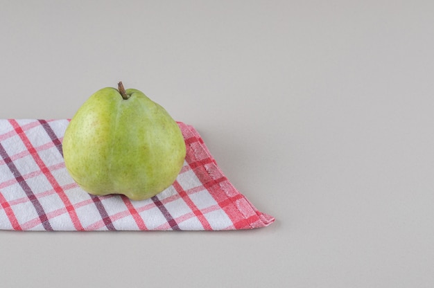 Free photo folded towel under a pear on marble