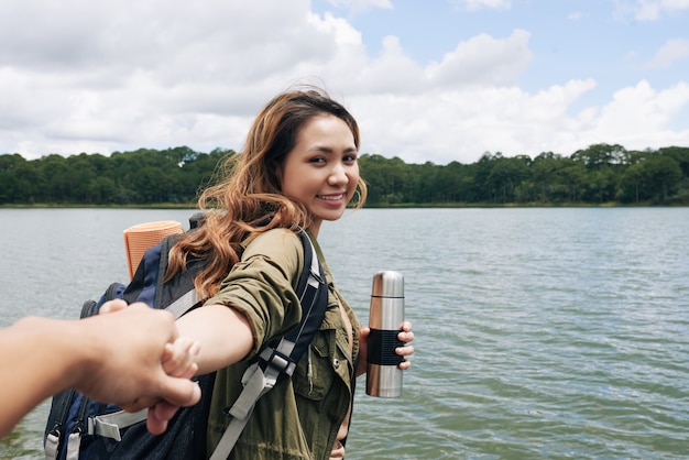 A follow me shot with Asian girl pulling a hand of her anonymous boyfriend and smiling