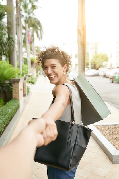 Follow me shot of woman turning to her unrecognizable woman holding her hand