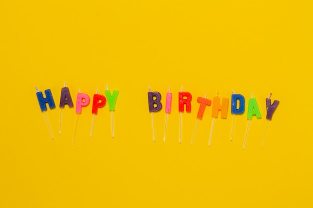 Fondo amarillo con confeti y las letras "happy birthday"