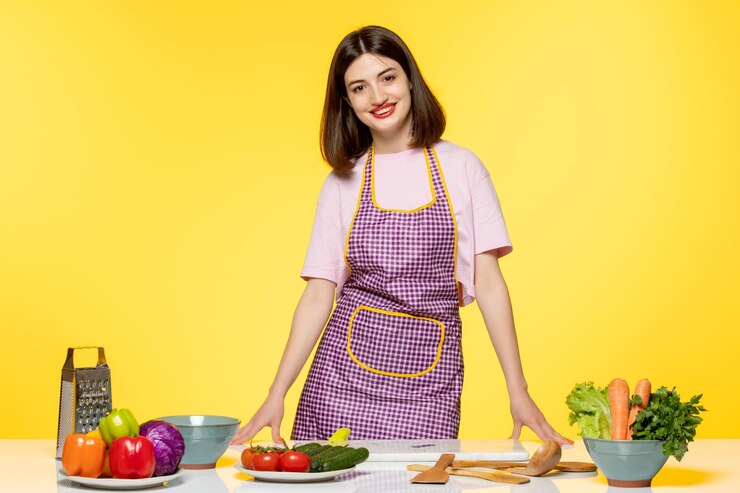 Free Photo food blogger cute lovely chef in pink apron recording video for social media standing happily
