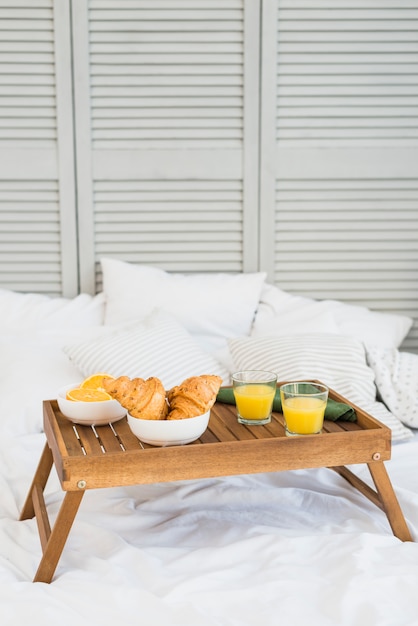 Food on breakfast table on bed