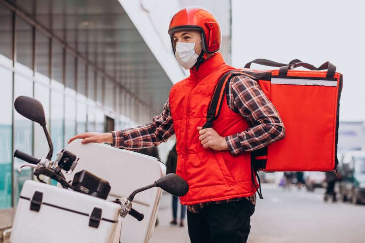 Free Photo food delivery boy driving scooter with box with food and wearing mask