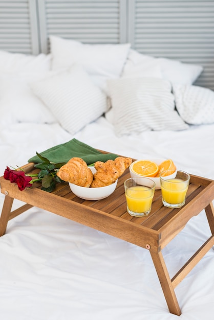 Foto gratuita cibo e fiori sul tavolo della colazione sul letto