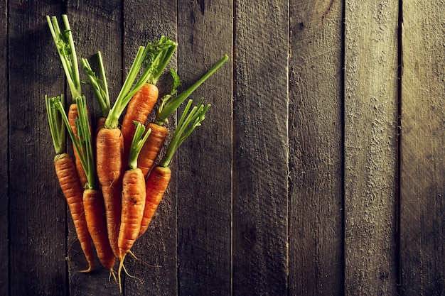 Foto gratuita sfondo colorato di verdure organiche di alimenti. carote fresche saporite sulla tavola di legno. vista superiore con lo spazio di copia. concetto di vita sana.