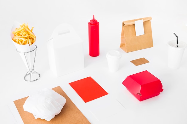 Foto gratuita pacchetti alimentari con patatine fritte e tazza di smaltimento su sfondo bianco