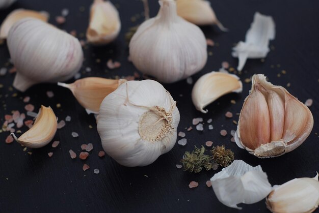 Food photography. food preparing. garlic with spices on black background. salt and pepper.
