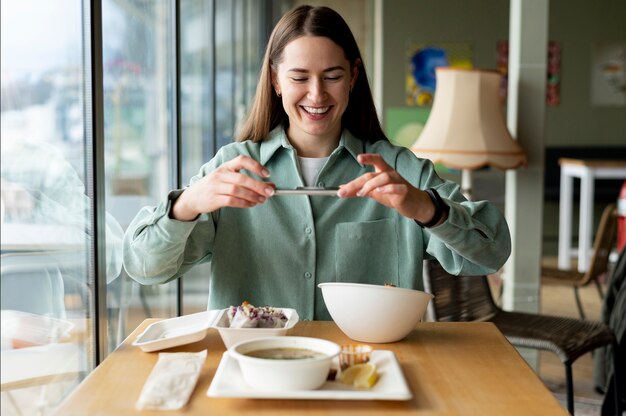 Foodie taking photo of a bowl with salad and a casserole of cabbage