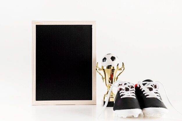 Football composition with leaning slate next to shoes