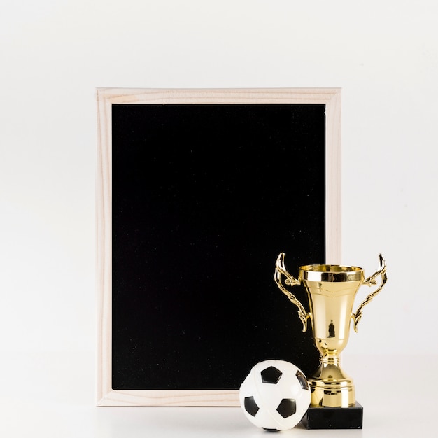 Free photo football composition with leaning slate and trophy