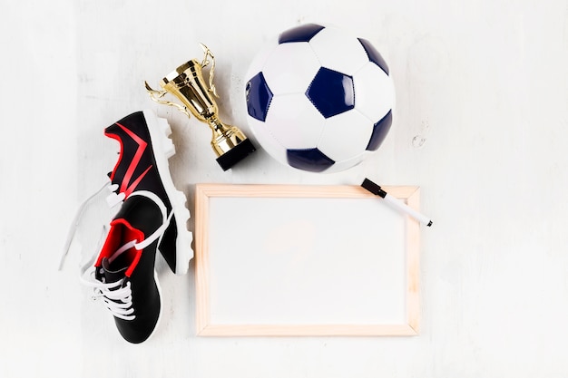 Free photo football composition with whiteboard and shoes