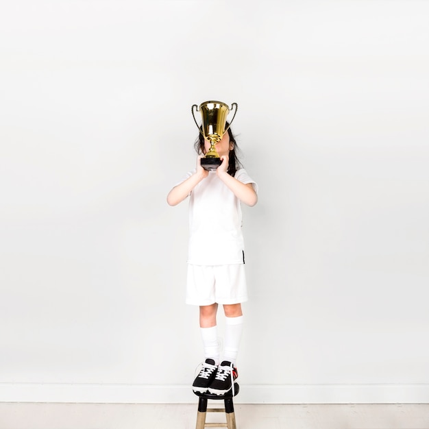 Free photo football concept with girl lifting trophy