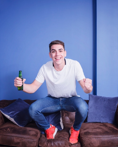 Football fan on couch with beer