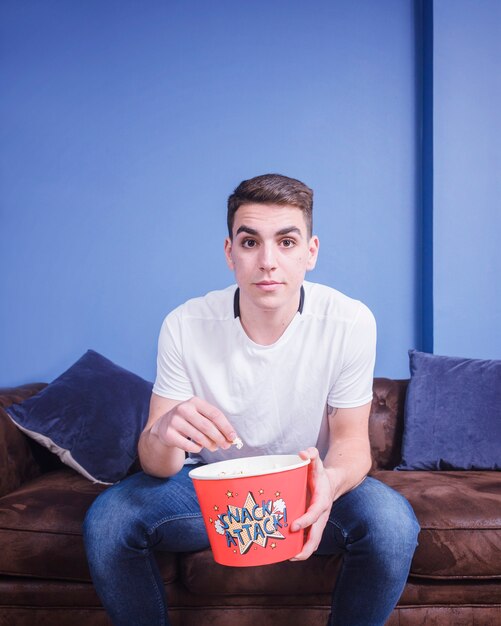 Football fan on couch with popcorn