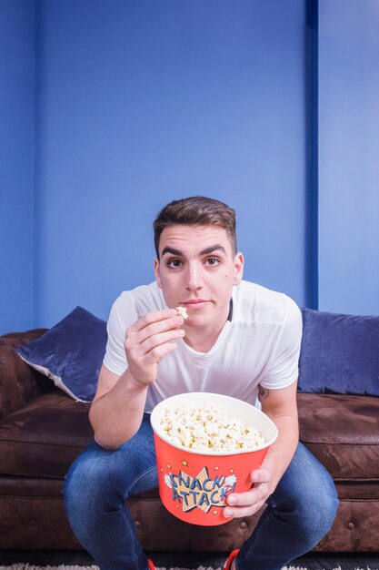 Football fan on couch with popcorn