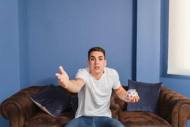 Football fan in disbelief on couch