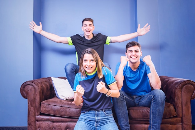 Free photo football fans celebrating on couch
