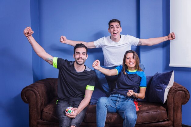 Football fans celebrating on couch