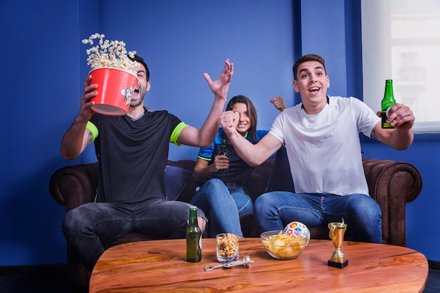 Football fans celebrating with popcorn