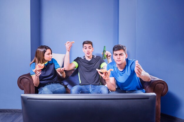 Football fans on couch behind tv