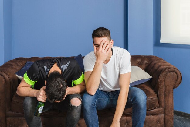 Free photo football fans in disbelief in living room