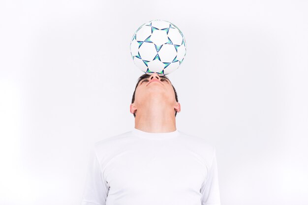 Football player balancing ball on head