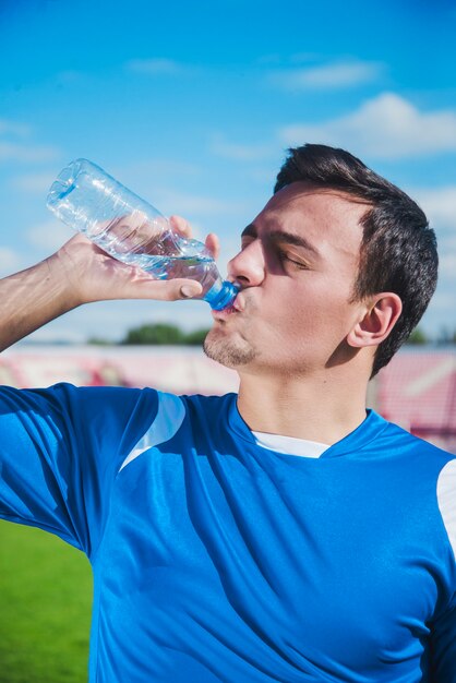 いくつかの水を飲むサッカー選手
