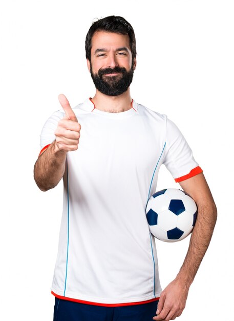 Football player holding a soccer ball with thumb up